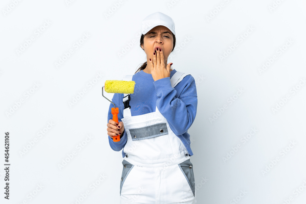 Painter woman over isolated white background yawning and covering wide open mouth with hand Painter woman over isolated white background yawning and covering wide open mouth with hand