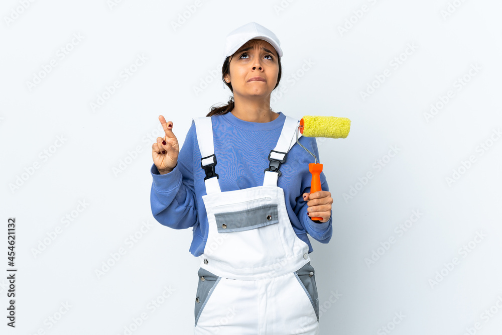 Painter woman over isolated white background with fingers crossing and wishing the best Painter woman over isolated white background with fingers crossing and wishing the best