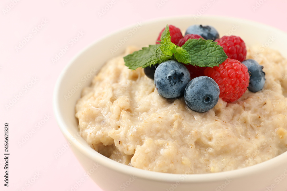 Tasty oatmeal porridge with raspberries and blueberries in bowl on light background, closeup Tasty oatmeal porridge with raspberries and blueberries in bowl on light background, closeup