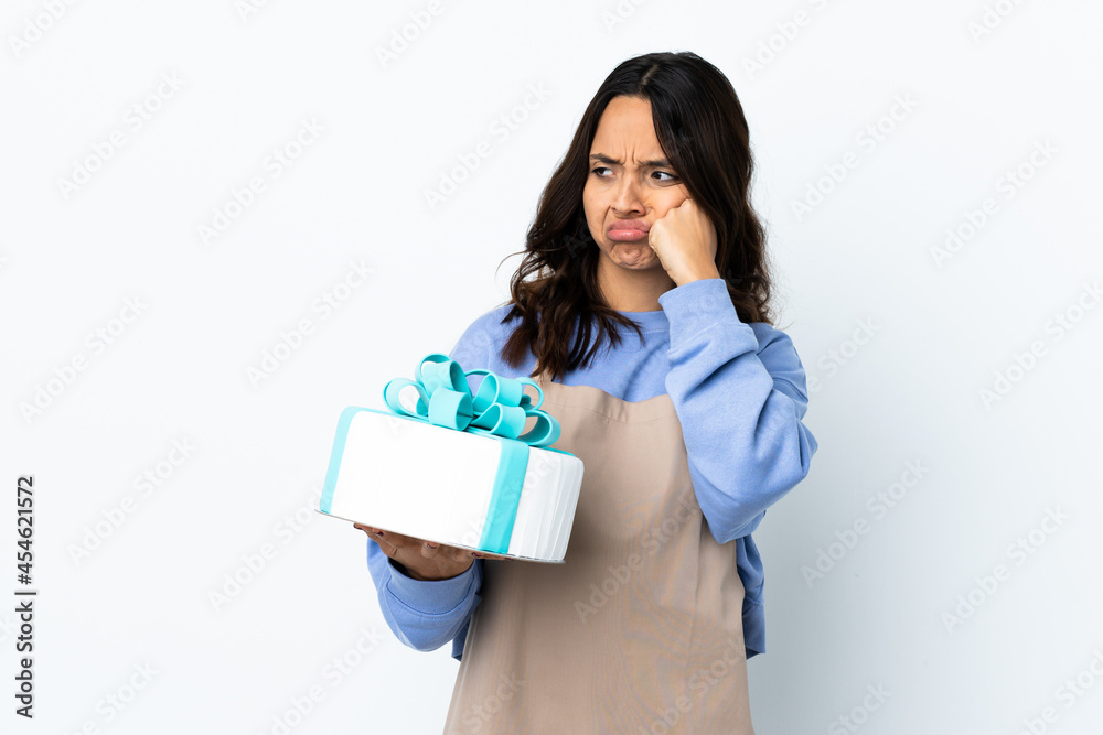 Pastry chef holding a big cake over isolated white background with tired and bored expression Pastry chef holding a big cake over isolated white background with tired and bored expression