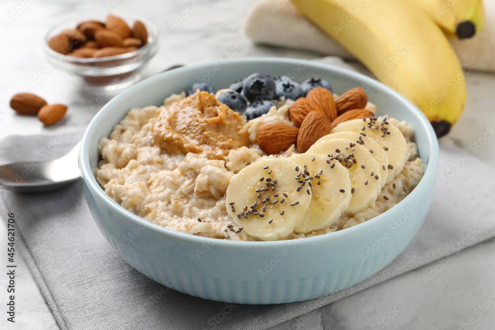 Tasty oatmeal porridge with toppings served on table Tasty oatmeal porridge with toppings served on table