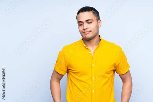 Asian handsome man over isolated background having doubts while looking side