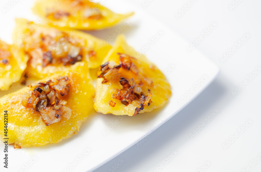 Fried dumplings sprinkled with fried onion, traditional Polish, Russian and Ukrainian cuisine Fried dumplings sprinkled with fried onion, traditional Polish, Russian and Ukrainian cuisine