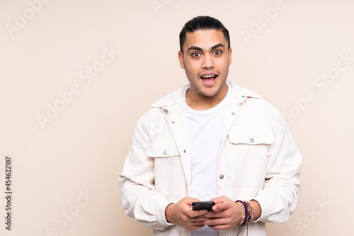 Asian handsome man over isolated background surprised and sending a message