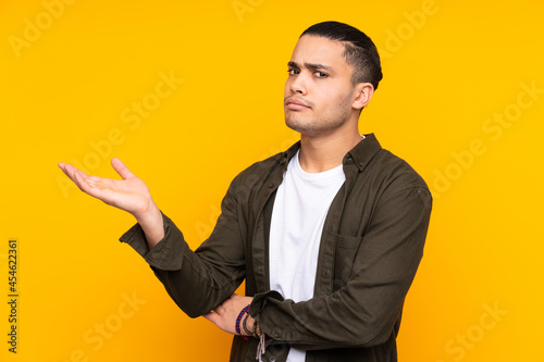 Asian handsome man isolated on yellow background celebrating a victory © luismolinero