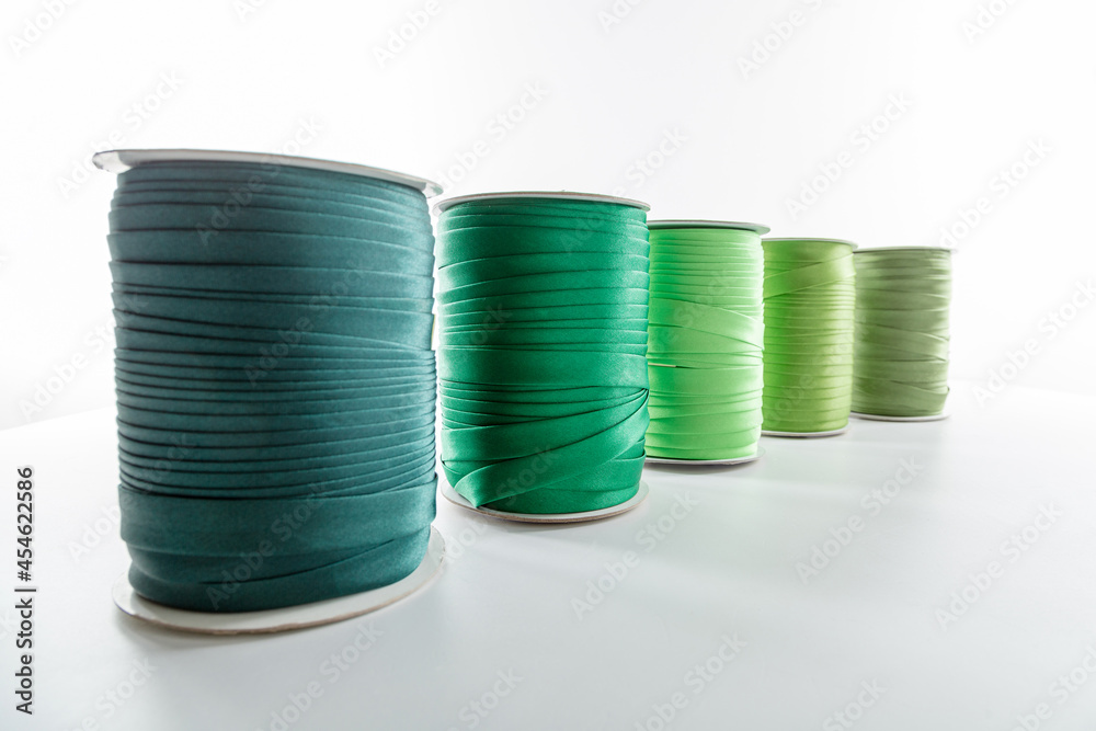 rolls with green decorative ribbons of different shades for clothes on a white background rolls with green decorative ribbons of different shades for clothes on a white background