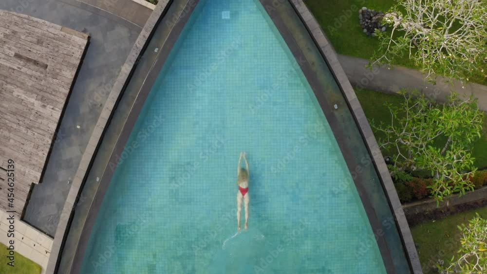 aerial view woman swimming in pool at tropical hotel spa with view of ...