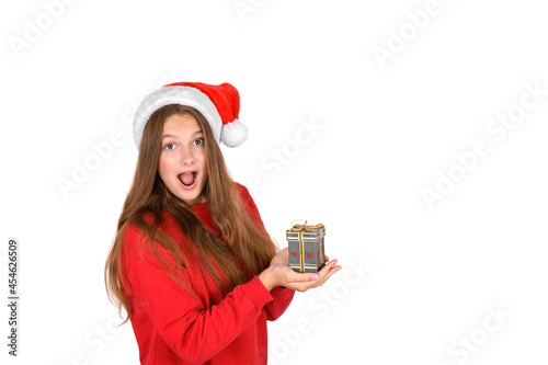 Portrait of crazy cool cheerful positive optimistic pretty woman in santa hat holding a present, looking surprised isolated on white background. Christmas emotion: joy, surprised, christmas sale banne photo