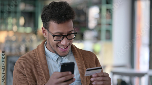African Man Excited by Online Shopping on Smartphone