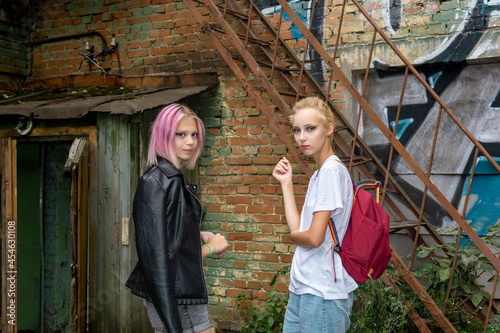two teenage girls retired in the courtyard of an old building