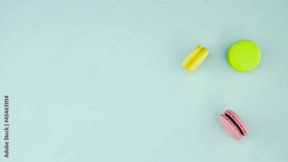 Top view of multicolored French Macarons cookies and a cup of coffee on a pastel blue background Top view of multicolored French Macarons cookies and a cup of coffee on a pastel blue background