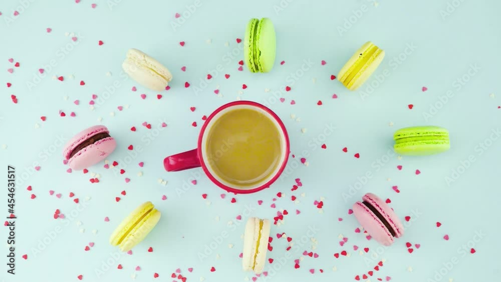 Top view of colorful cookies, French Macarons, and a cup of coffee on a pastel blue background with beautifully scattered confetti Top view of colorful cookies, French Macarons, and a cup of coffee on a pastel blue background with beautifully scattered confetti