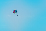 Extreme sports and exciting rest. Tourist fly on a parashute in the blue sky background