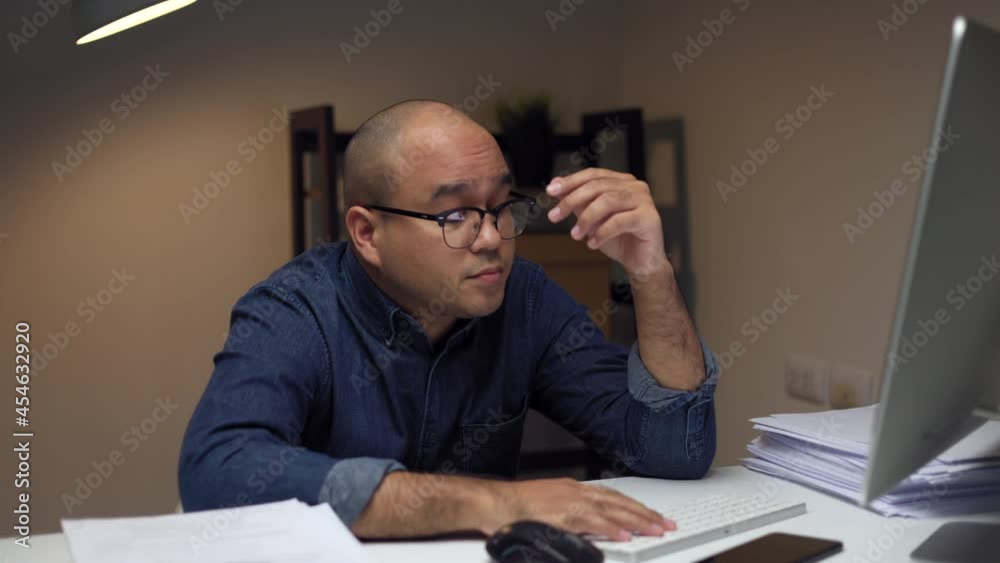 Young businessman freelancer works with computer late at night in a dimly lit room. He was tired and sleepy. He yawned and wanted to sleep.
Young businessman freelancer works with computer late at night in a dimly lit room. He was tired and sleepy. He yawned and wanted to sleep.