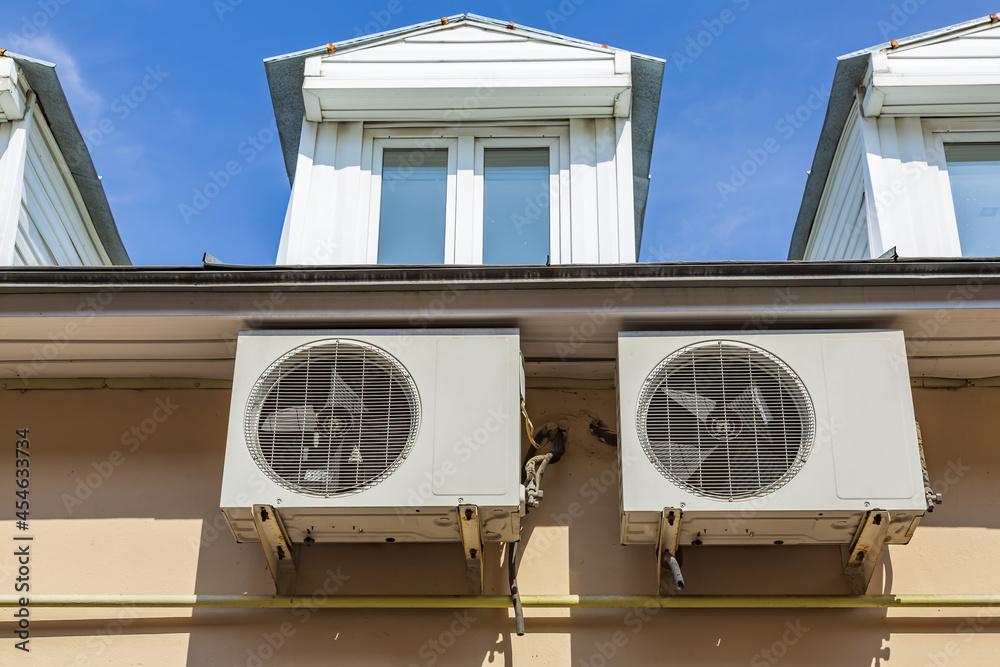 External box of an old air conditioner with a fan on the stone wall of