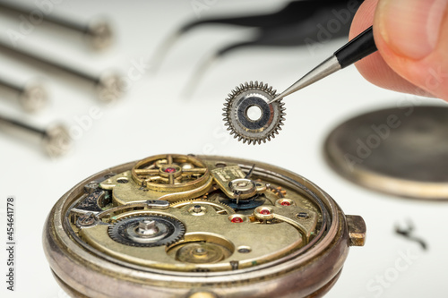 WATCHMAKER REPAIRING A WATCH IN THE WORKSHOP. CLOSE UP..