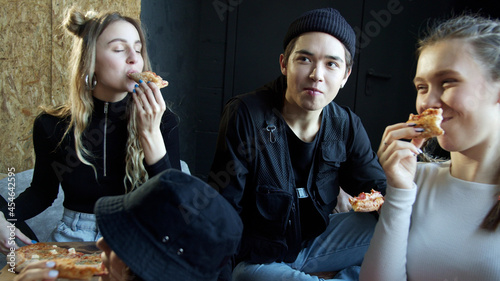 Young hipsters eating pizza in a dance studio