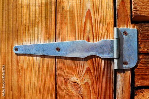 hinges on a wooden door in yellow tones