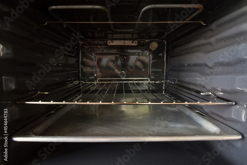 Selective blur on the inside of a built in integrated electric oven, in the interior with it resistance and metal grill, clean, brand new, ready for use as household appliance for cooking and baking