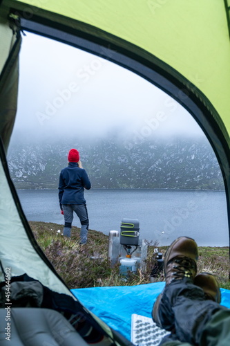 First-person view from the tent. The concept of travel and camping in the wild. Shore, gasfire. Travel equipment. Active lifestyle. 
 photo