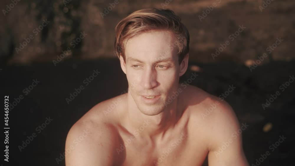 Portrait of young Caucasian man with sharp cheekbones looking to the camera. Beautiful man with masculine chin and wide neck glance to the camera. Concept of man's beauty. High quality 4k footage
