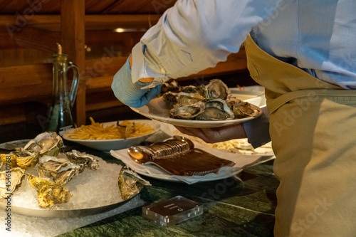 Waiter catching oysters on a plate