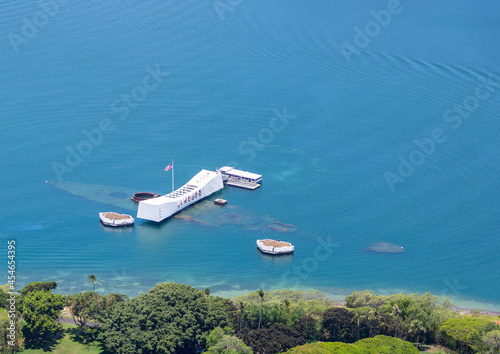 Aerial view of the USS Arizona memorial in Pearl Harbor, Hawaii. USS Arizona is visible underwater. Ample copy space in blue water.