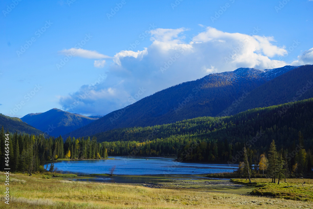 The Bay of the Gods at Kanas Lake. Tranquil water, trees, mysterious clouds.