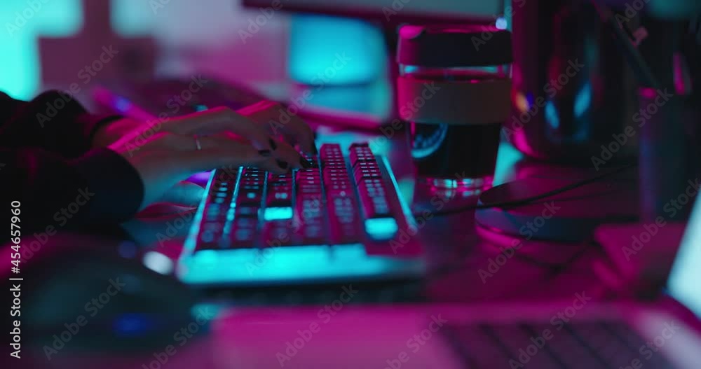 computer hands typing on keyboard programmer coding hacking data on internet cyber crime information hack by anonymous hacker using rgb gaming keyboard with blue backlight