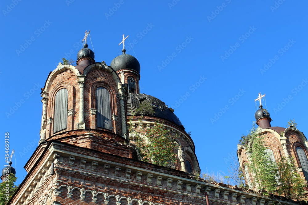 Fototapeta premium The dome of an old abandoned church stands against the summer sky.