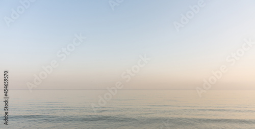 Calm evening sea surface with clear blue sky. Evening seascape. 