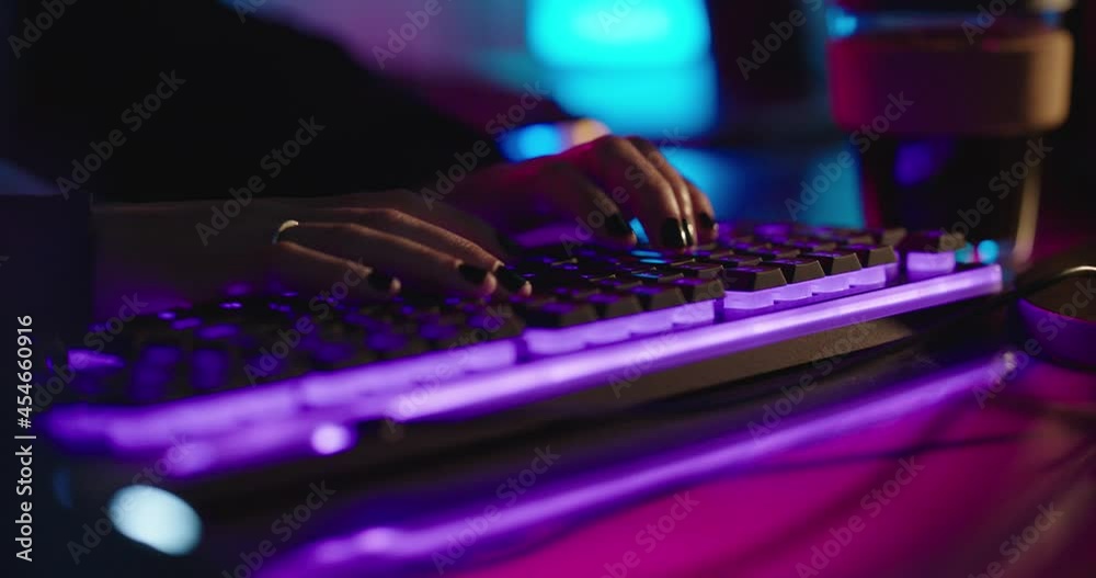 computer hands typing on keyboard gamer playing online game anonymous person hacking data browsing online usinggaming keyboard with purple nean backlight