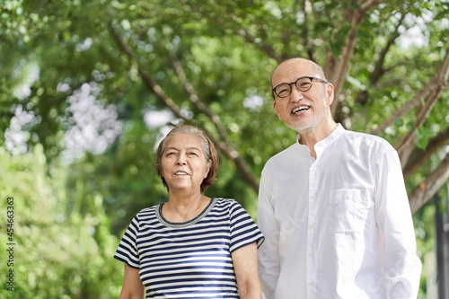 笑顔で公園を散歩する高齢者の夫婦 © mapo