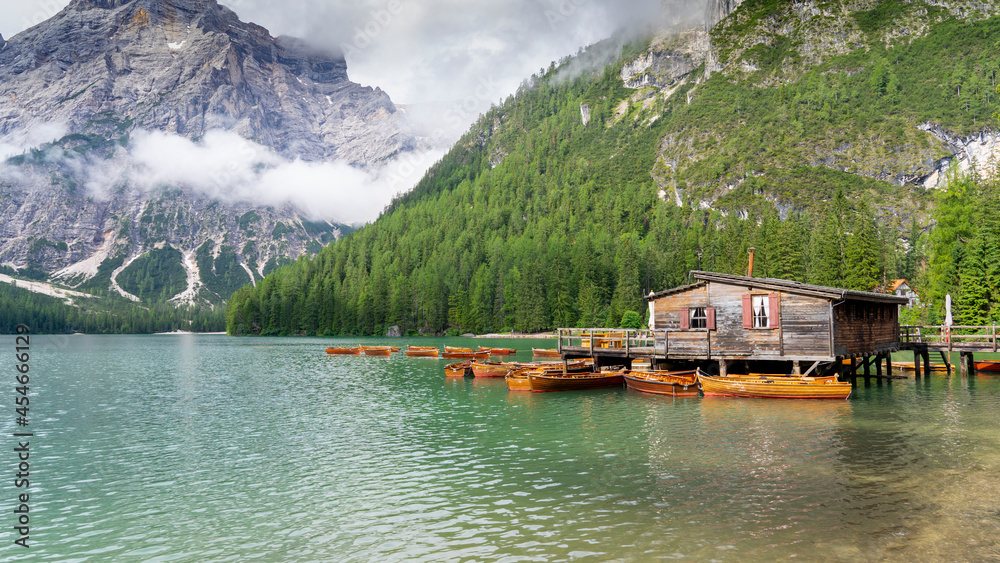 Lake Braies, Italy. Group of the traditional rowing boats docked to the wood house. Iconic location for photographers. Picturesque mountain lake in Dolomites. Wonderful nature contest. Alpine lake