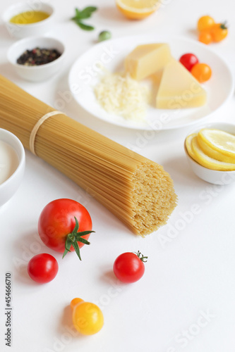 Ingredients for Italian pasta on a white background. Vegetarian food. Homemade food. Close-up copy space.