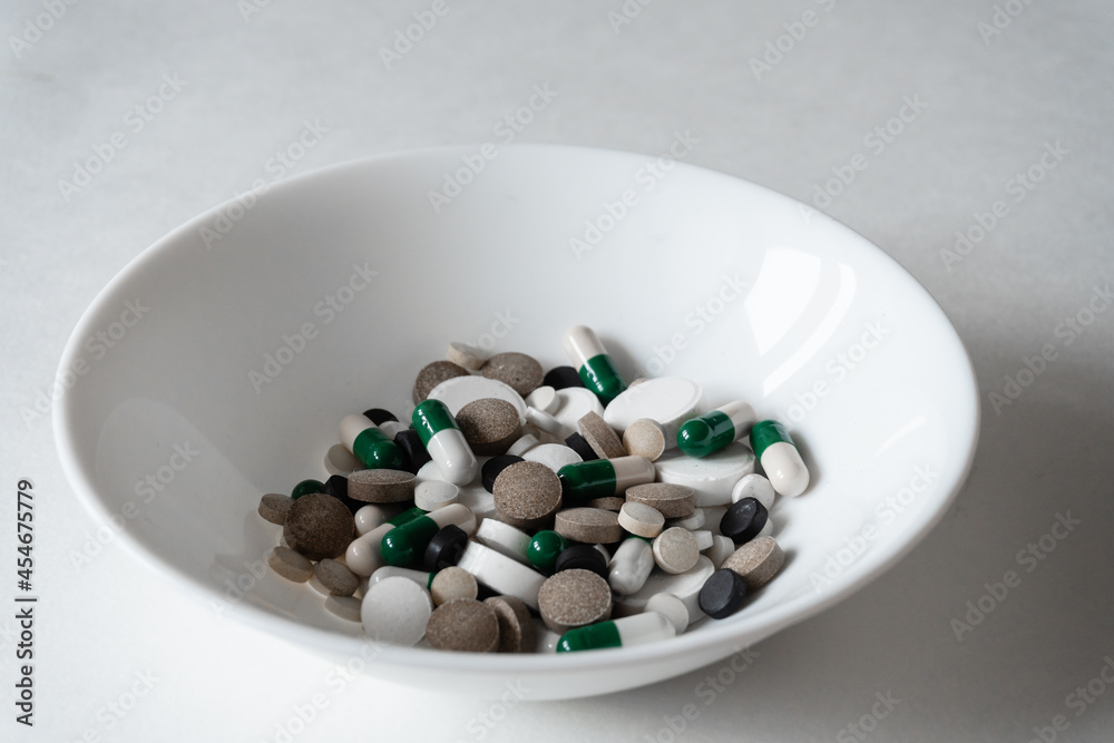 white plate with Different tablets and pills at white background white plate with Different tablets and pills at white background