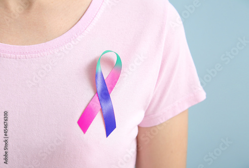 Young woman with colorful ribbon, closeup. Thyroid cancer awareness concept