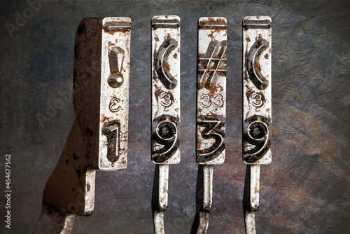 Fotografie vintage old typewriter hammers with the date 1939 with vintage wallpaper backgro