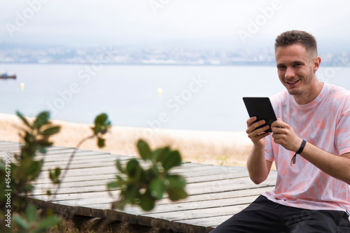 young man with digital tablet outdoors