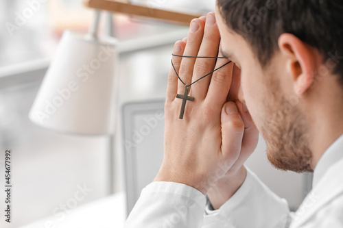 Religious doctor praying in...