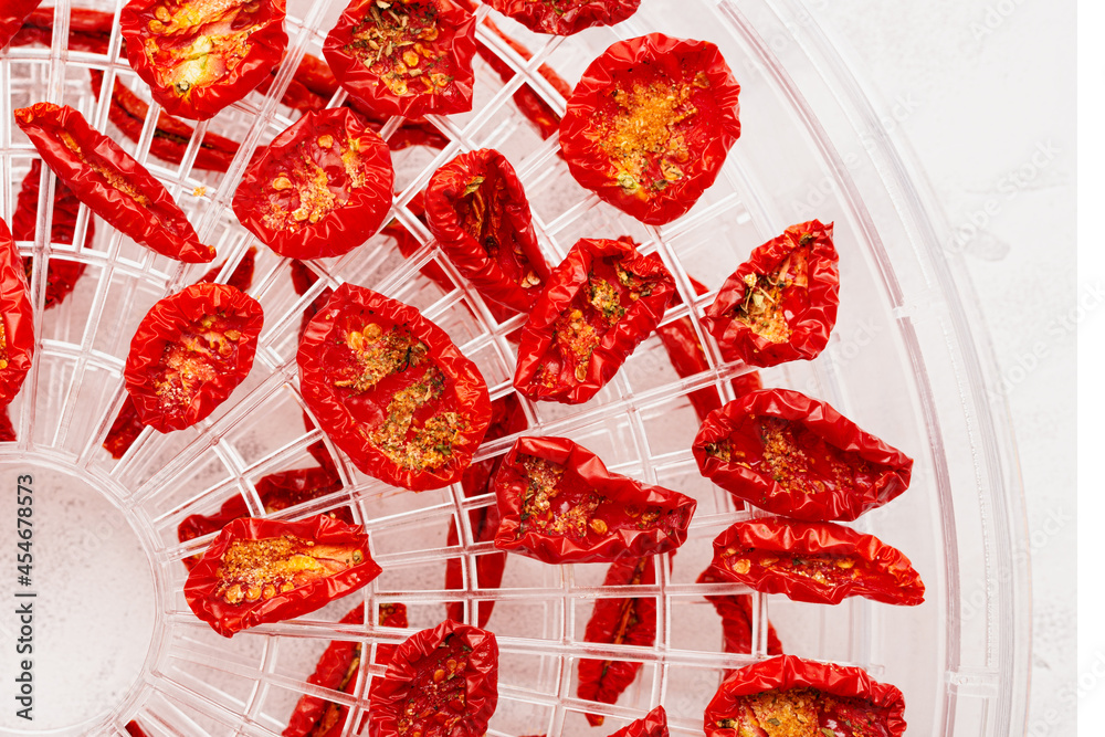 Fototapeta premium Sun-dried tomatoes in a plastic dehydrator tray top view