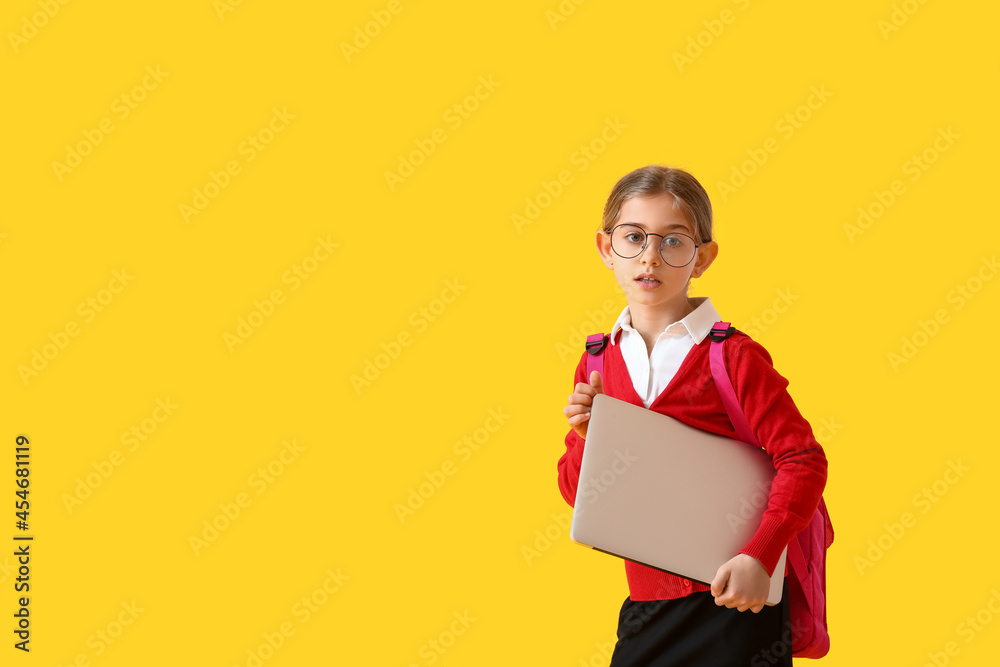 Cute little school girl with laptop on color background Cute little school girl with laptop on color background