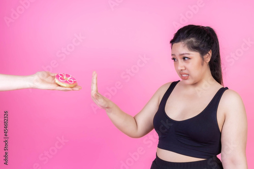 Asian fat women , Fat girl , Chubby, Plump woman ,overweight plus size , she refuses to eat donuts because it's very hostile to her weight loss - Woman diet weight loss overweight problem concept