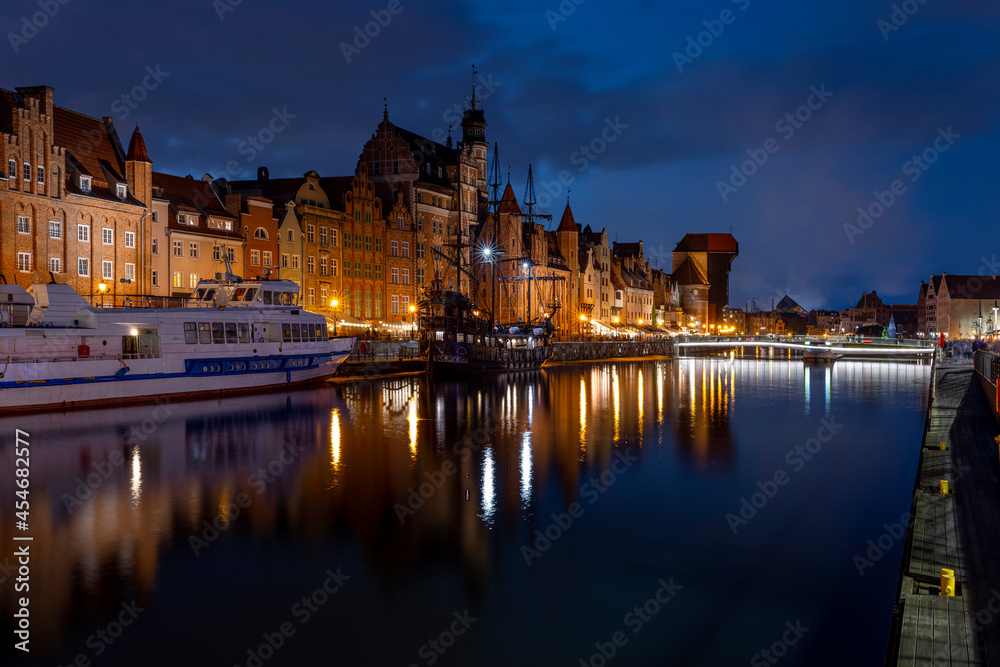 Gdask old town - houses and gate crane on the Motawa River in the evening time - bridge, pirate ship and tourist ship