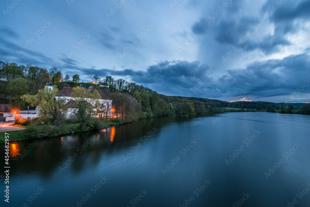 Wallfahrtskirche Mariaort und der Fluss Naab bei Regensburg während der blauen Stunde im Zwielicht und Wolken nach einem Gewitter Sturm, Deutschland