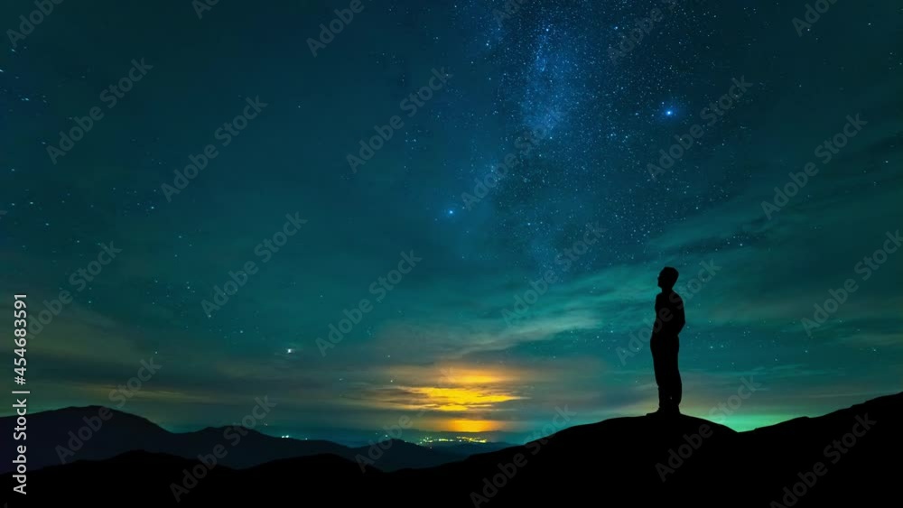 The man stand on mountain top on a starry sky background. time lapse The man stand on mountain top on a starry sky background. time lapse
