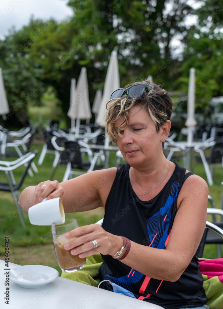 Fototapeta premium mujer tomando cafe en una terraza de un bar al aire libre