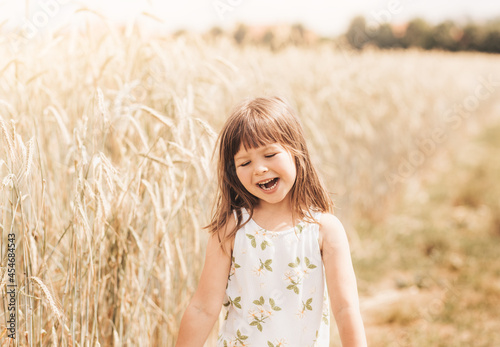 Close-up portrait of a smiling little girl blonde in nature in the summer
