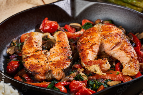 Salmon with vegetables cooked in a cast iron skillet