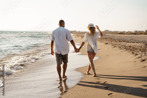 Photography Young beautiful couple walking on beach near sea